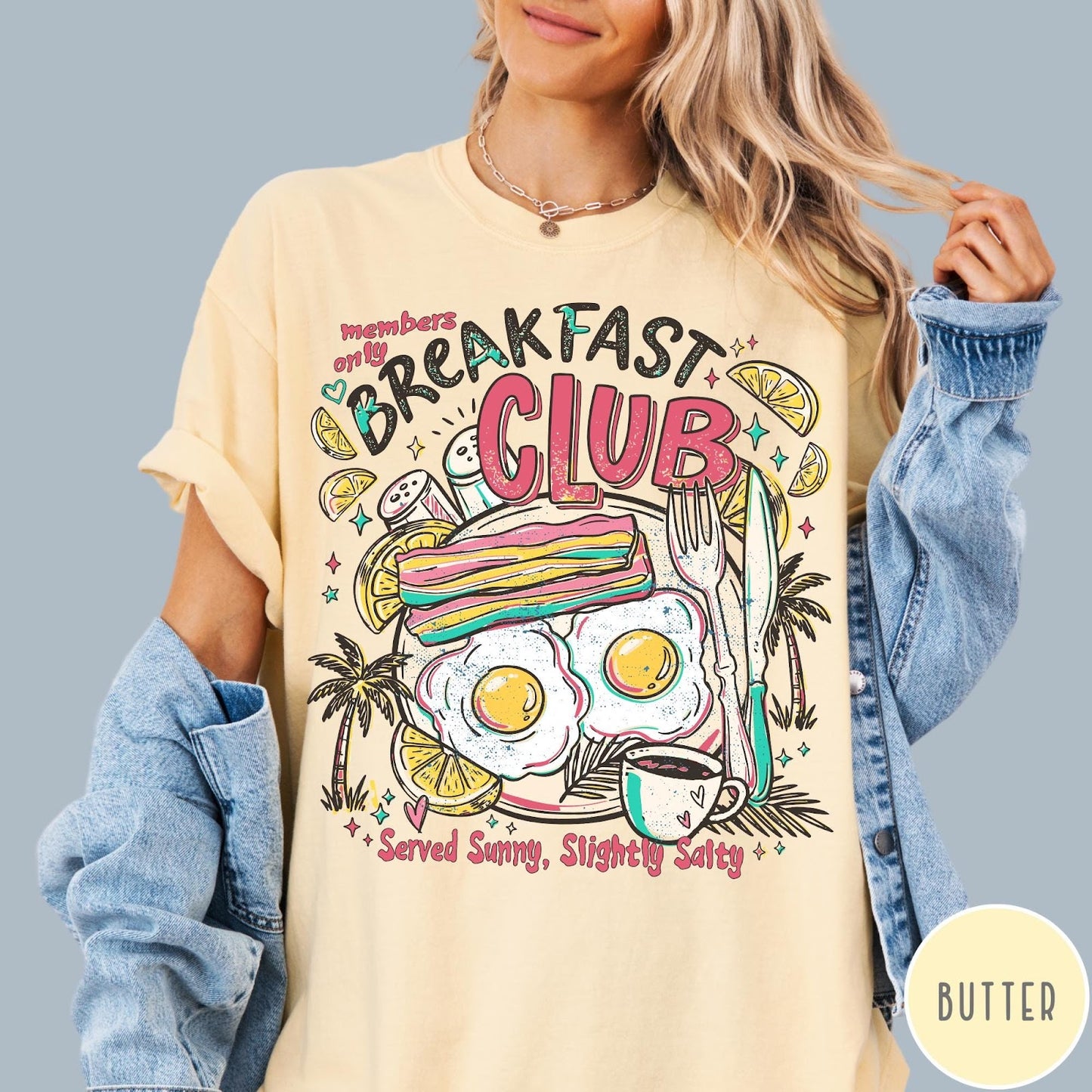 Comfort Colors tee in Butter featuring breakfast food graphic with bacon, eggs, coffee, and palm trees.