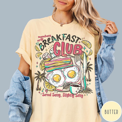 Comfort Colors tee in Butter featuring breakfast food graphic with bacon, eggs, coffee, and palm trees.