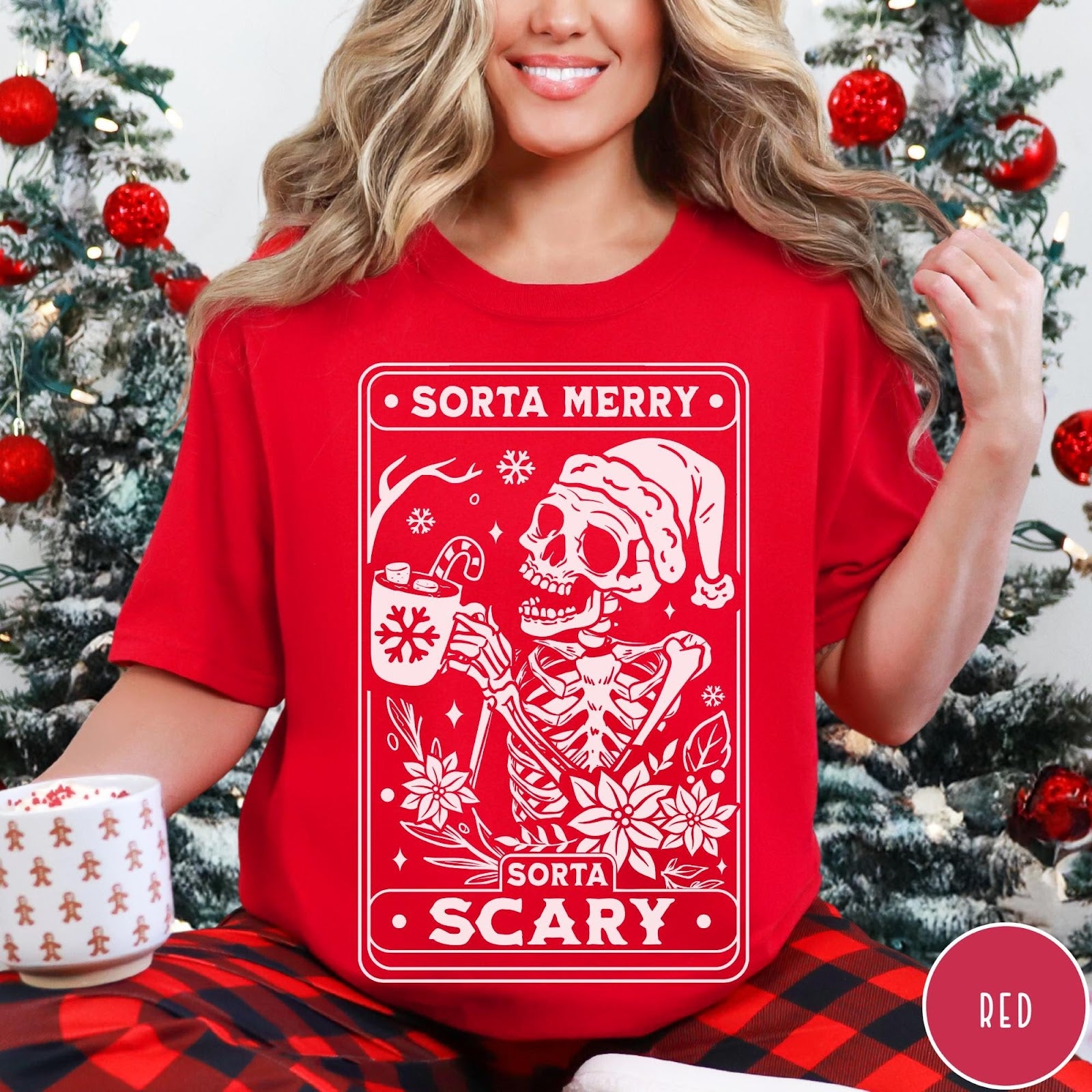 Comfort Colors tee in Red featuring graphic design of a skeleton in a Santa hat holding cocoa