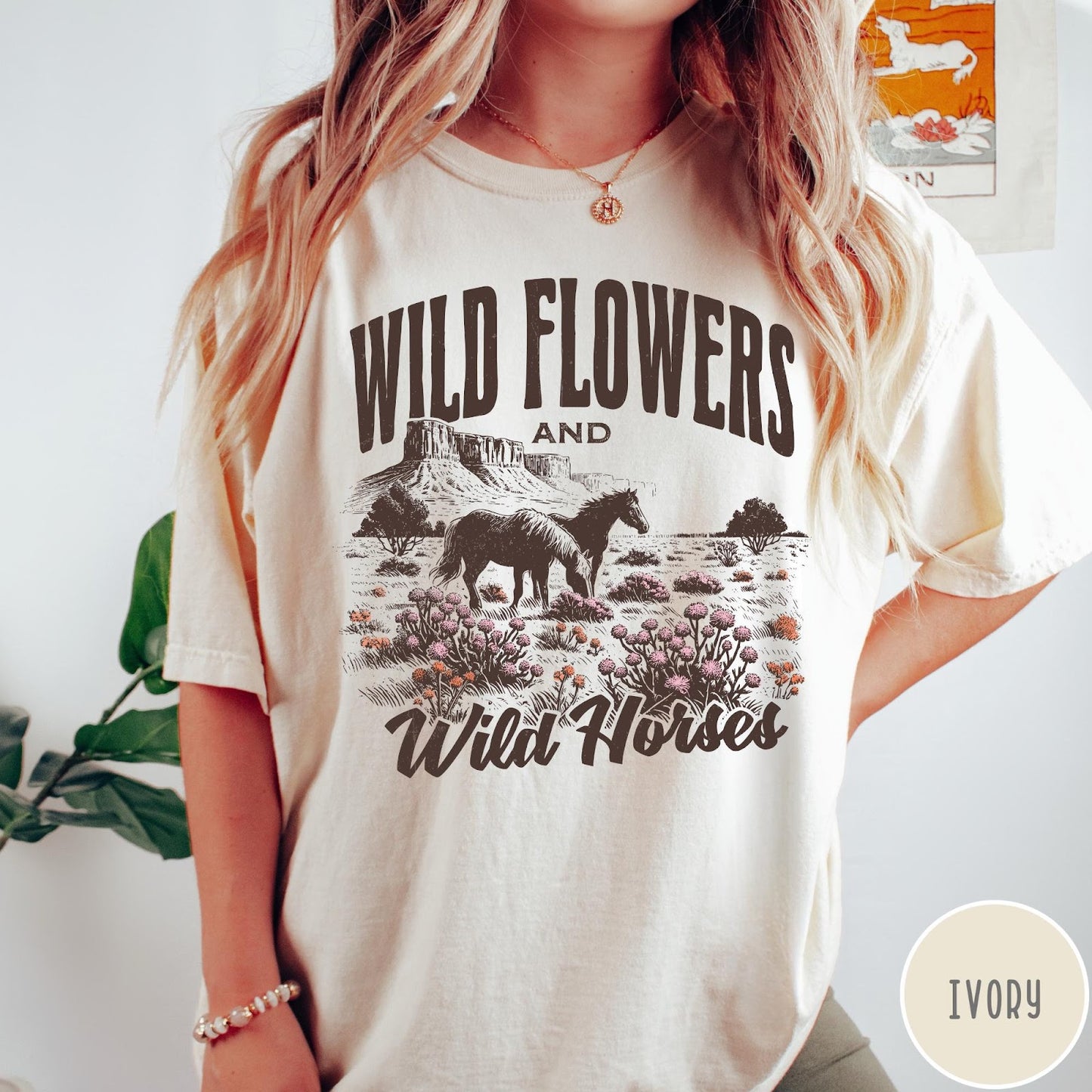 Comfort Colors tee in Ivory featuring western style graphic of wild horses grazing in a wildflower field