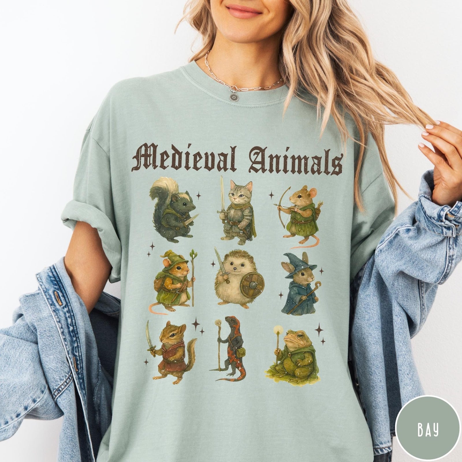 Comfort Colors tee in Bay featuring medieval animals graphic with fantasy characters including a cat, hedgehog, and frog