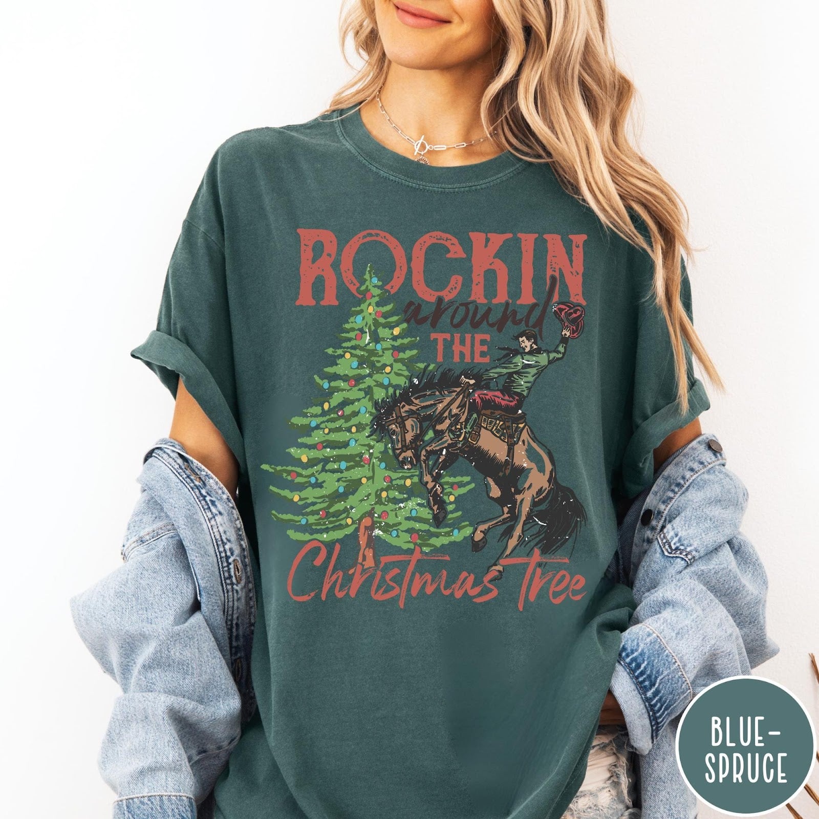 Comfort Colors tee in Blue Spruce featuring western graphic design of a cowboy on a bucking horse Christmas tree