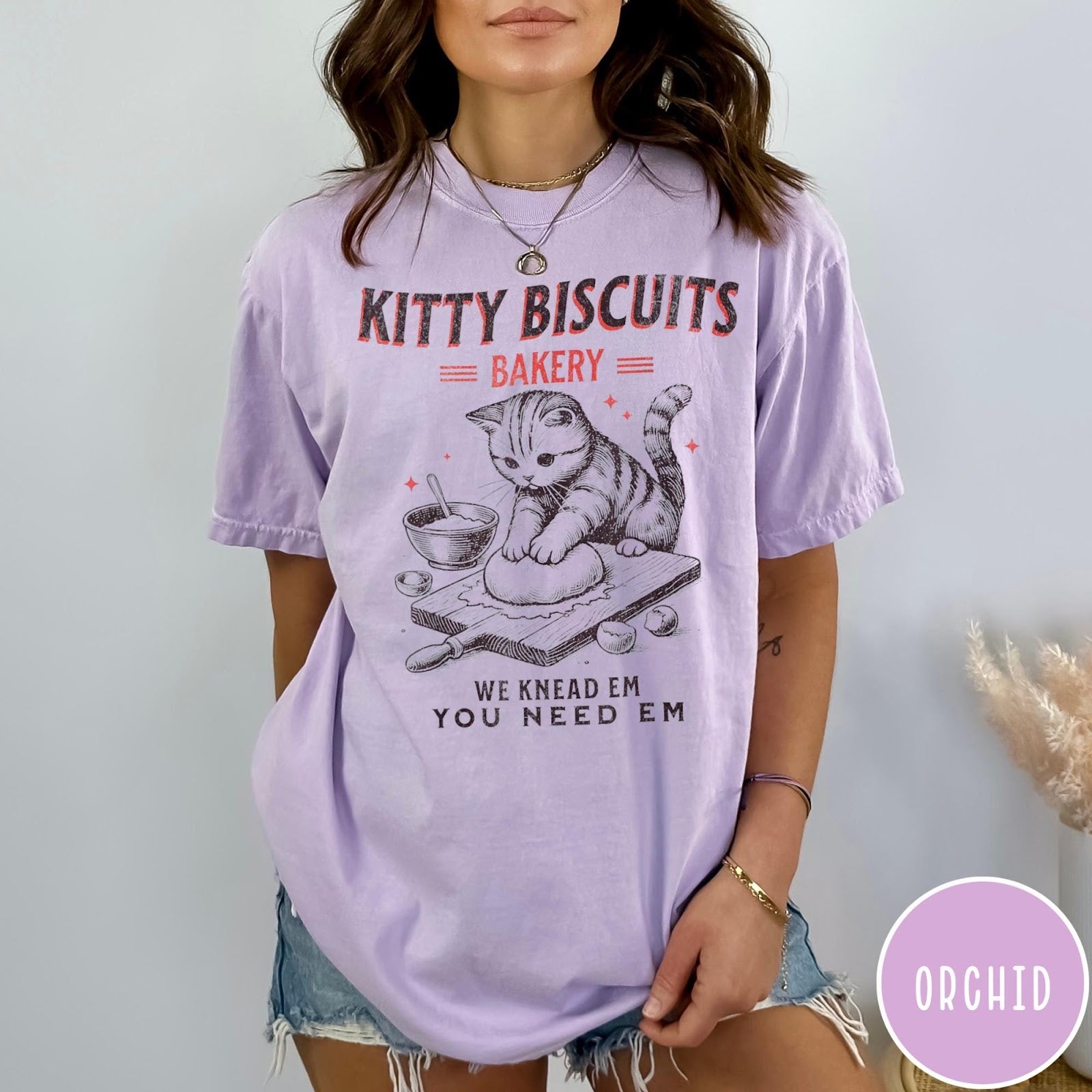 Comfort Colors tee in Orchid featuring vintage style graphic of a cute cat kneading dough for biscuits