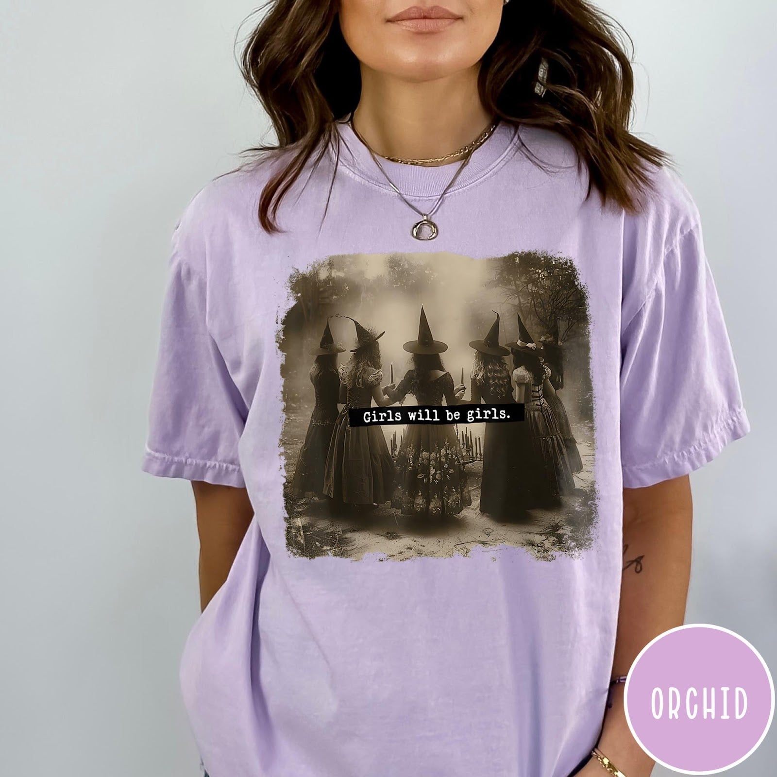 Comfort Colors tee in Orchid featuring vintage style graphic of five witches standing in a circle together