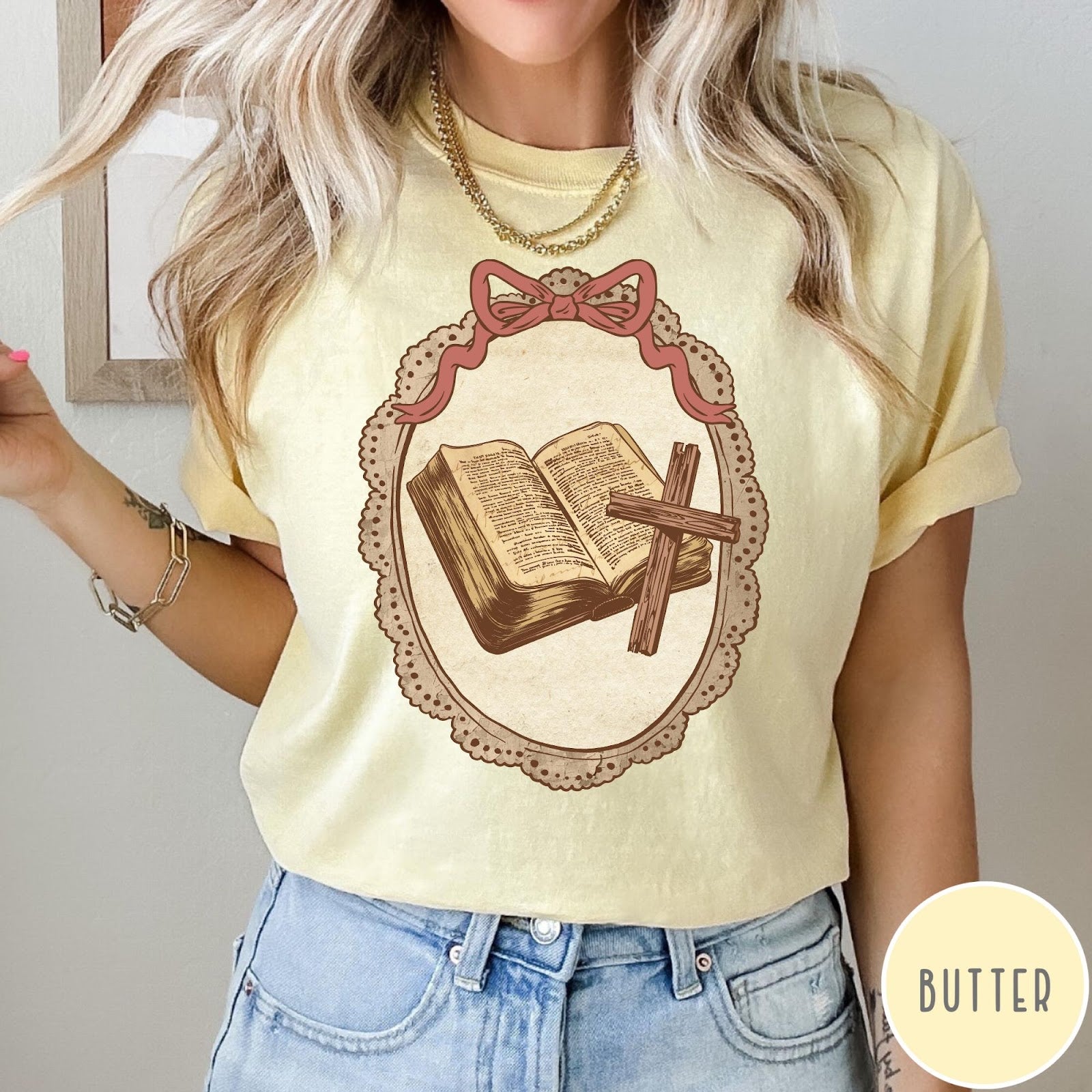 Comfort Colors tee in Butter featuring vintage style graphic of an open Bible and wooden Christian cross.