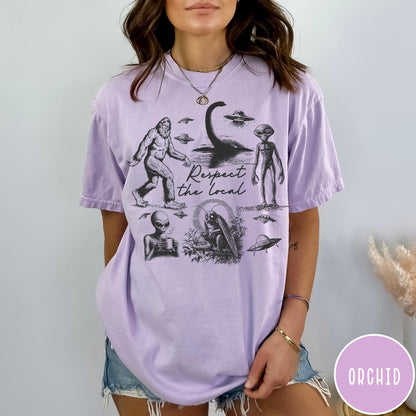 Comfort Colors tee in Orchid featuring vintage style cryptid graphic with Bigfoot, UFOs, and alien creatures.