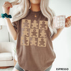 Comfort Colors tee in Espresso featuring a grid design with nine smiling gingerbread cookie illustrations in light beige