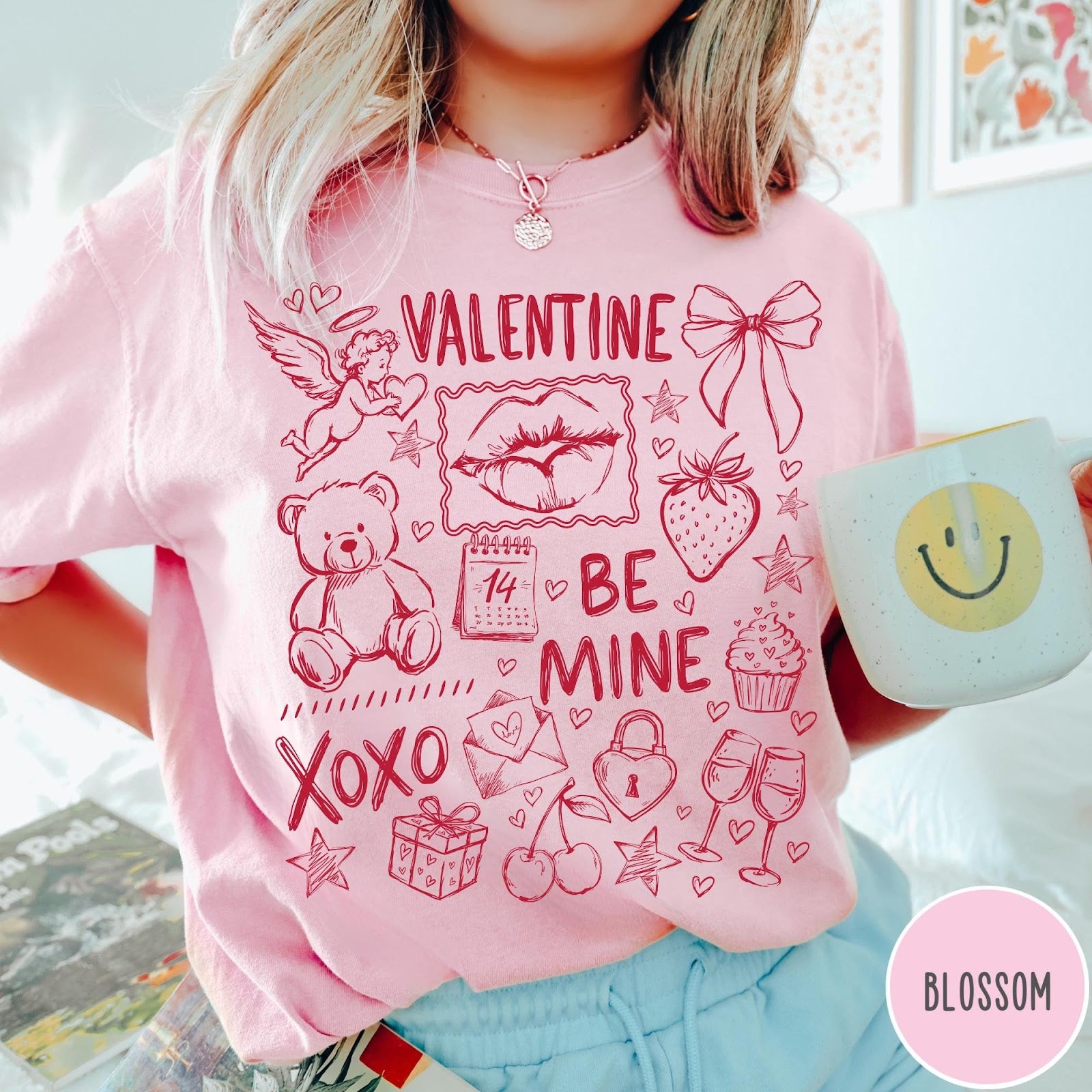 Comfort Colors tee in Blossom featuring sketch style Valentine's Day collage graphic with cupid, bear, and hearts