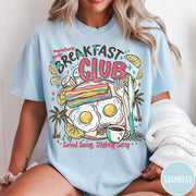 Comfort Colors tee in Chambray featuring breakfast food graphic with bacon, eggs, coffee, and palm trees.