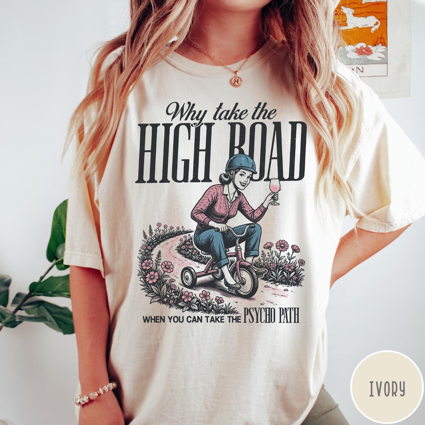 Comfort Colors tee in Ivory featuring vintage style graphic of a woman riding a tricycle with wine