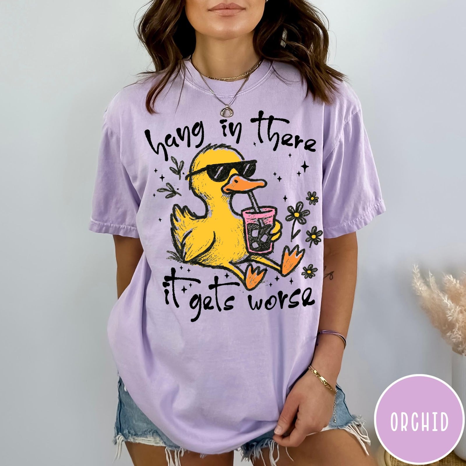 Comfort Colors tee in Orchid featuring illustrated duck graphic wearing sunglasses and drinking a pink iced beverage