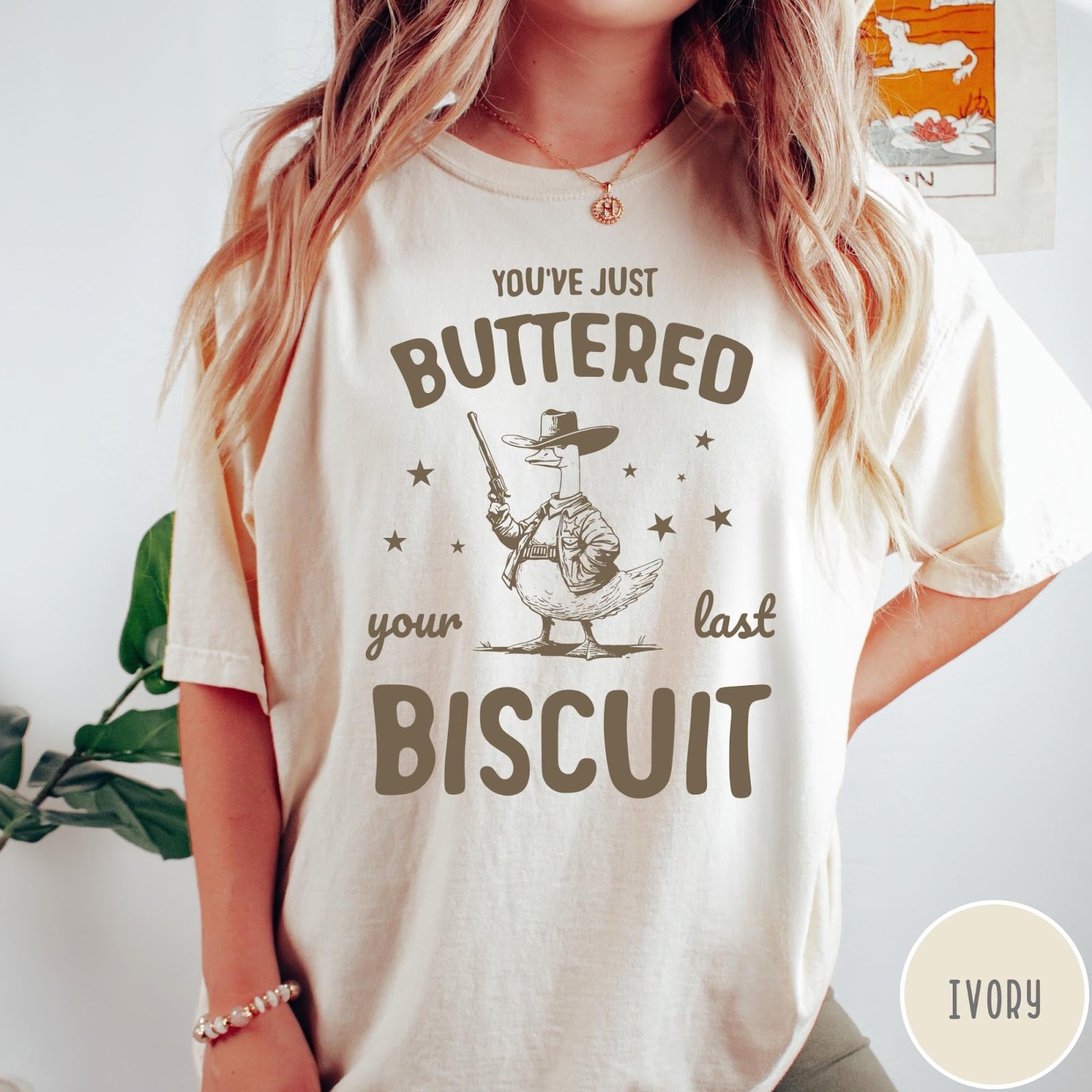 Comfort Colors tee in Ivory featuring western graphic style cowboy goose holding a revolver with star accents