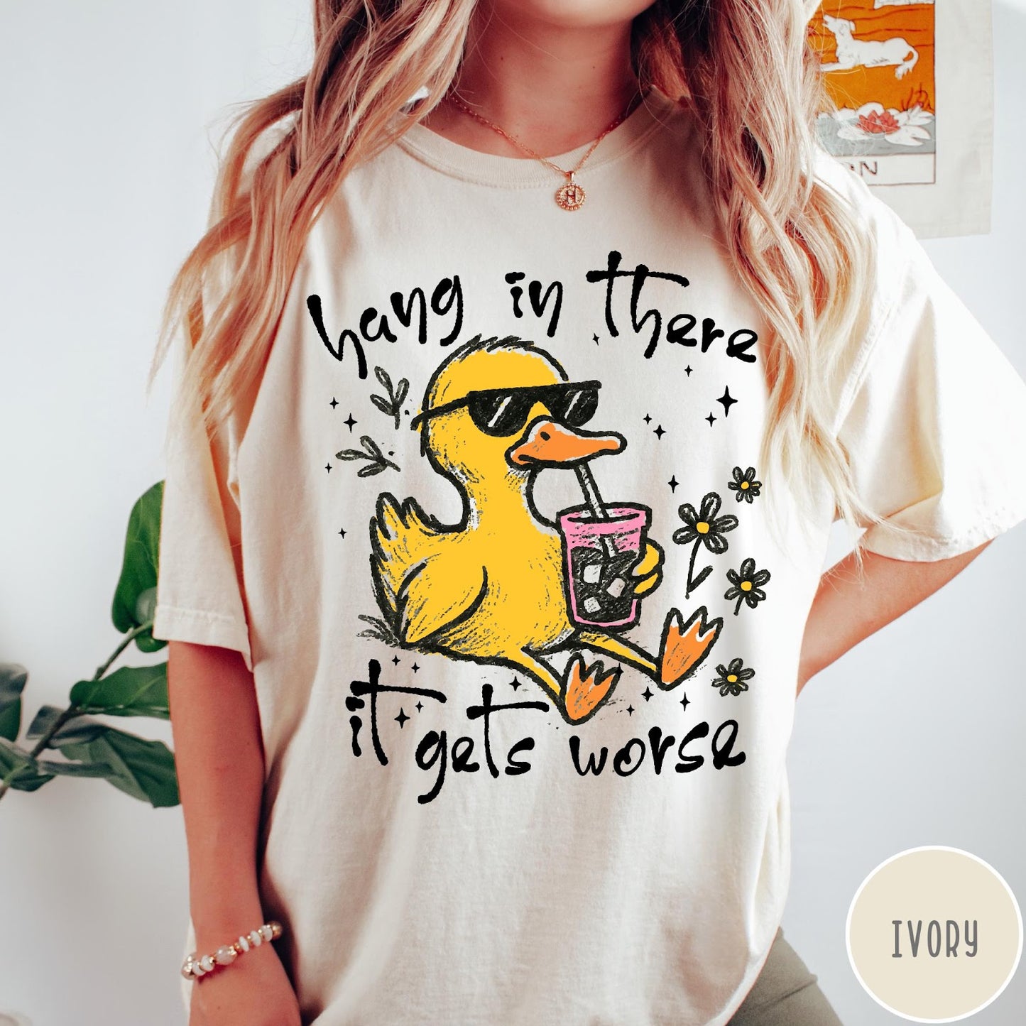 Comfort Colors tee in Ivory featuring illustrated duck graphic wearing sunglasses and drinking a pink iced beverage