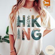 Comfort Colors tee in Ivory featuring nature graphic with trees and mountains inside the word Hiking