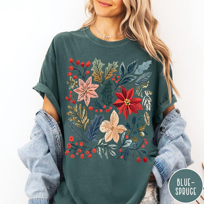 Comfort Colors tee in Blue Spruce featuring winter florals graphic with poinsettias, holly leaves, and red berries.