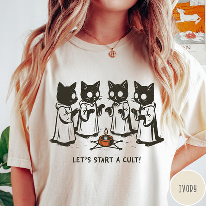 Comfort Colors tee in Ivory featuring illustrated style graphic of four cats in robes around a candle