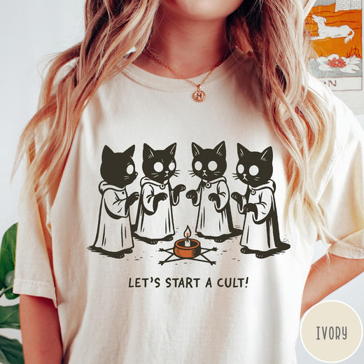 Comfort Colors tee in Ivory featuring illustrated style graphic of four cats in robes around a candle