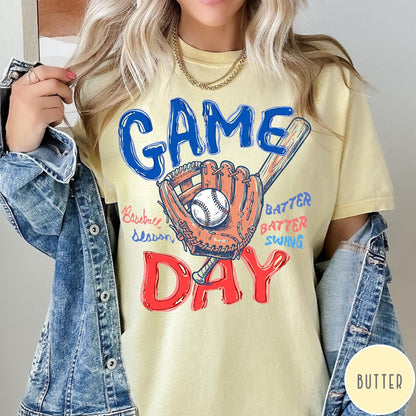 Comfort Colors tee in Butter featuring baseball design with glove, ball, bat, and Game Day text graphic