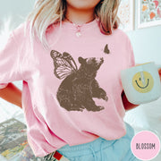 Comfort Colors tee in Blossom featuring vintage style graphic of a bear with butterfly wings and butterfly