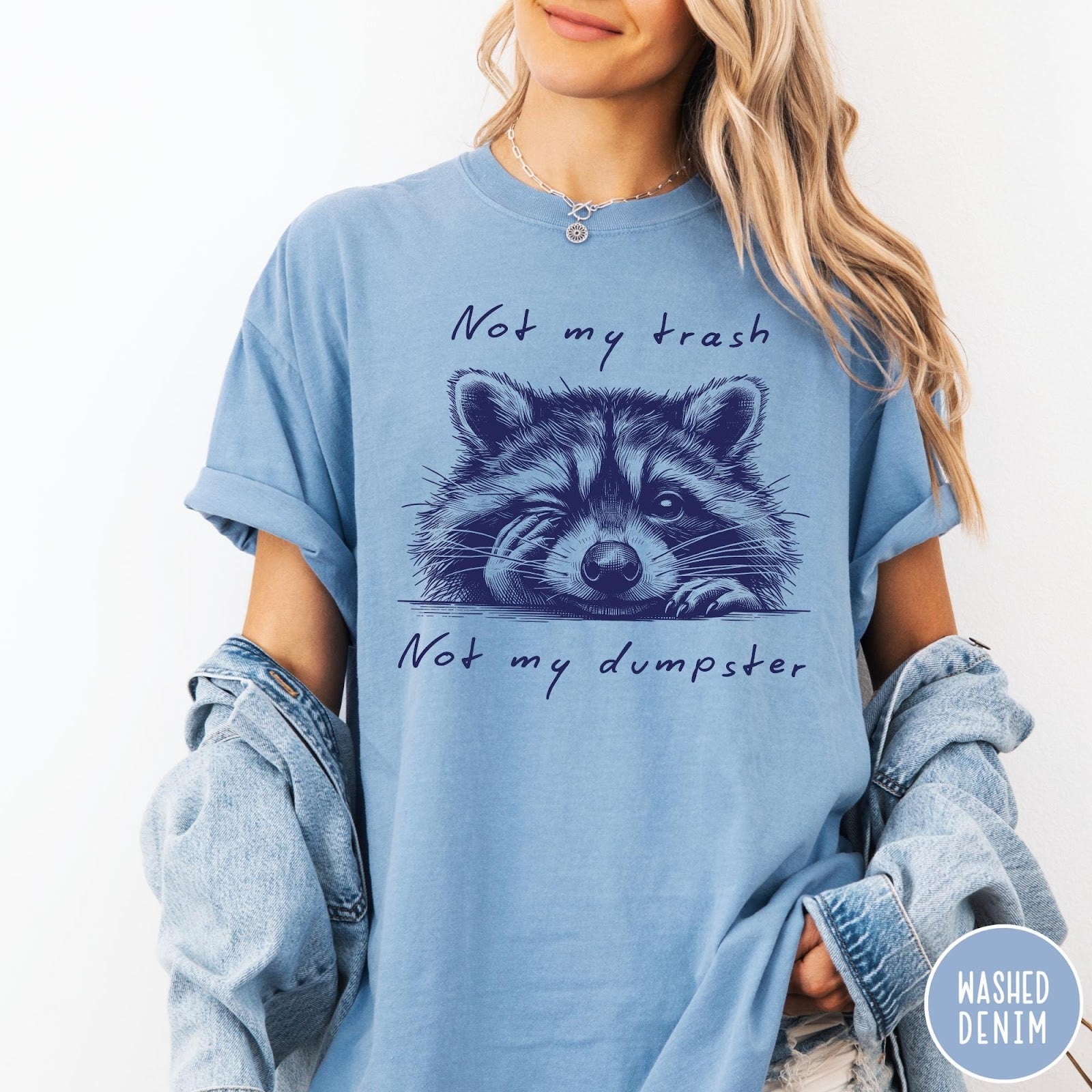 Comfort Colors tee in Washed Denim featuring graphic illustration of a winking raccoon with text Not My Trash