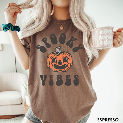 Comfort Colors tee in Espresso featuring retro style graphic with a smiling pumpkin and Spooky Vibes text