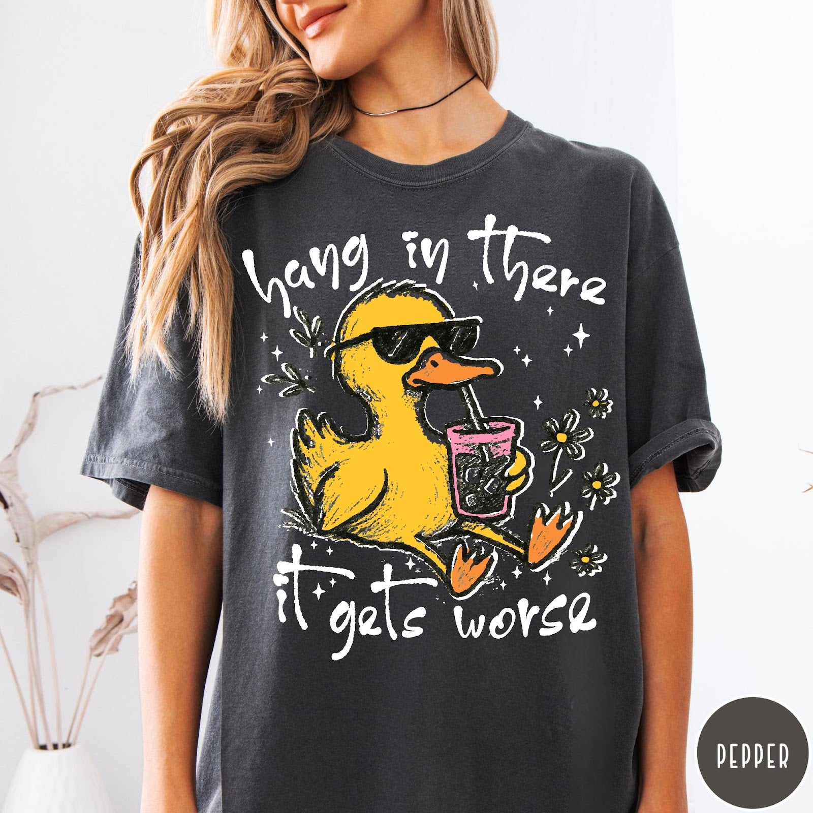 Comfort Colors tee in Pepper featuring illustrated duck wearing sunglasses and drinking iced coffee with floral accents