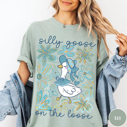 Comfort Colors tee in Bay featuring whimsical graphic style with a goose wearing a bonnet and floral border
