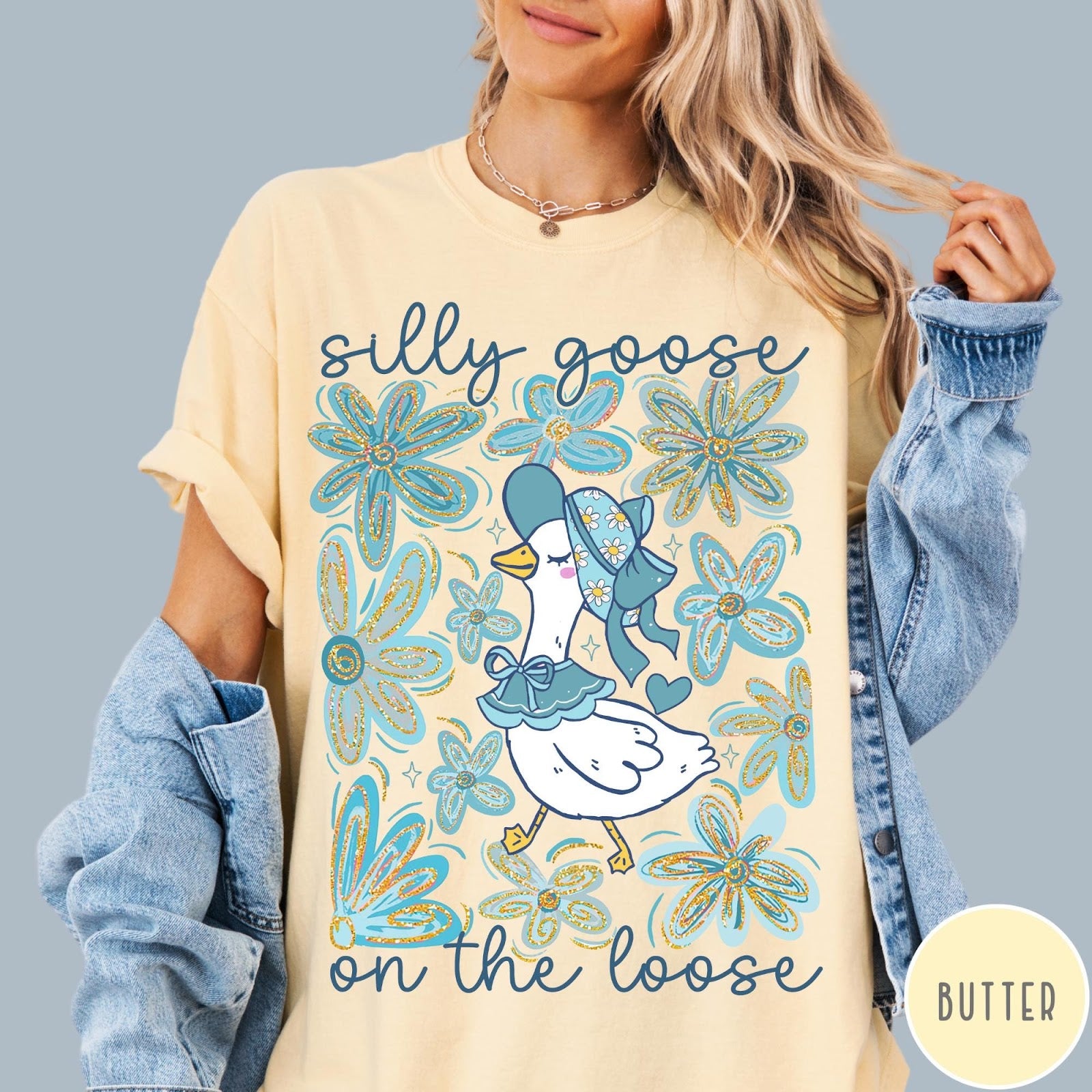 Comfort Colors tee in Butter featuring whimsical graphic style with a goose wearing a bonnet and floral border