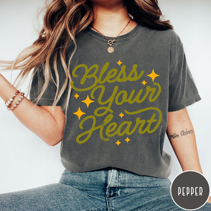 Comfort Colors tee in Pepper featuring script lettering and star accents with the phrase Bless Your Heart