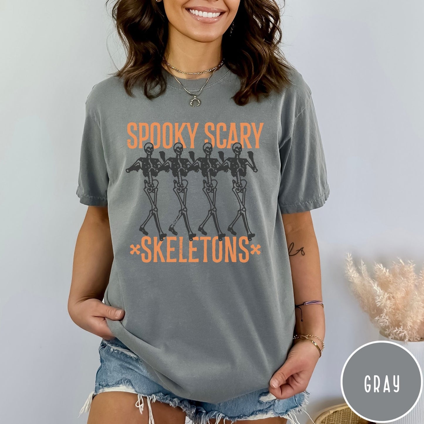 Comfort Colors tee in Gray featuring dancing skeletons graphic with Spooky Scary Skeletons text in orange
