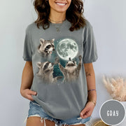 Comfort Colors tee in Gray featuring artistic graphic of three raccoons reaching toward a bright full moon