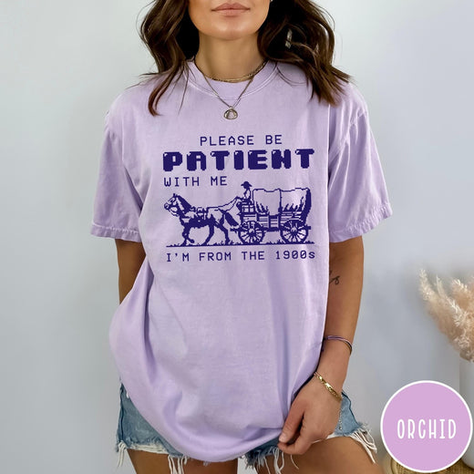 Comfort Colors tee in Orchid featuring pixel art style graphic of a horse drawn covered wagon