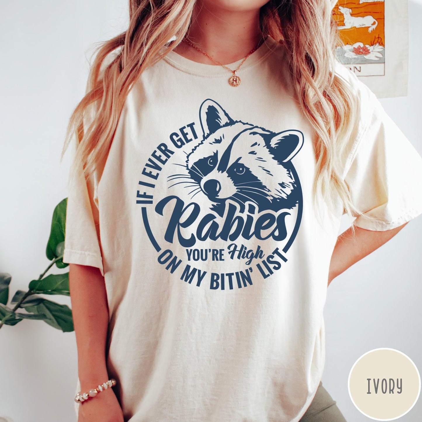 Comfort Colors tee in Ivory featuring screen print style graphic of a raccoon with funny rabies text