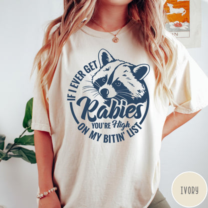 Comfort Colors tee in Ivory featuring screen print style graphic of a raccoon with funny rabies text