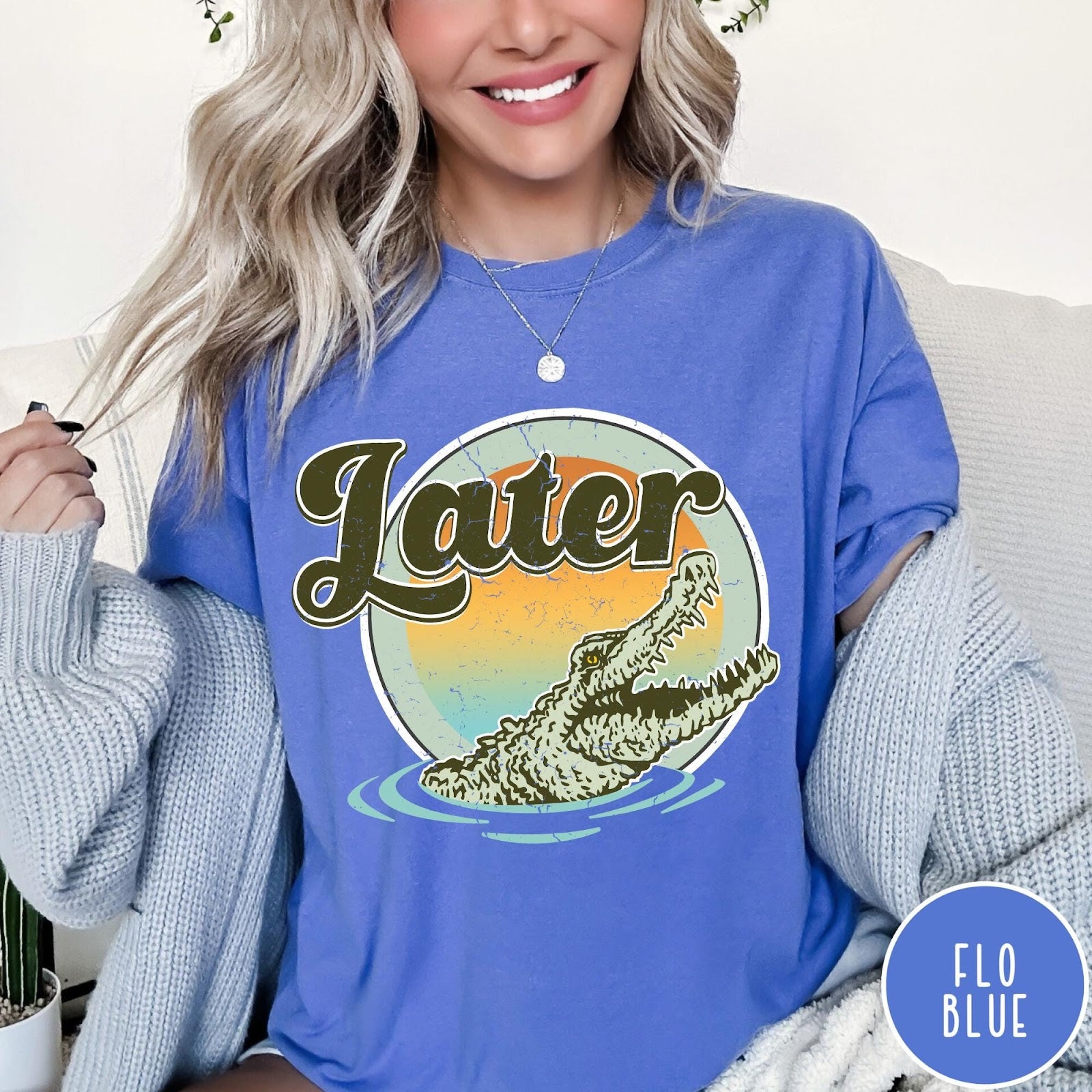 Comfort Colors tee in Flo Blue featuring vintage style graphic of an alligator emerging from water with sunset background