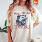 Comfort Colors tee in Ivory featuring illustrative opossum graphic with text First Of All I'm A Delight