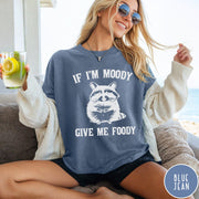 Comfort Colors tee in Blue Jean featuring vintage style graphic of a raccoon with text If I'm Moody Give Me Foody