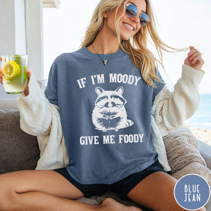 Comfort Colors tee in Blue Jean featuring vintage style graphic of a raccoon with text If I'm Moody Give Me Foody
