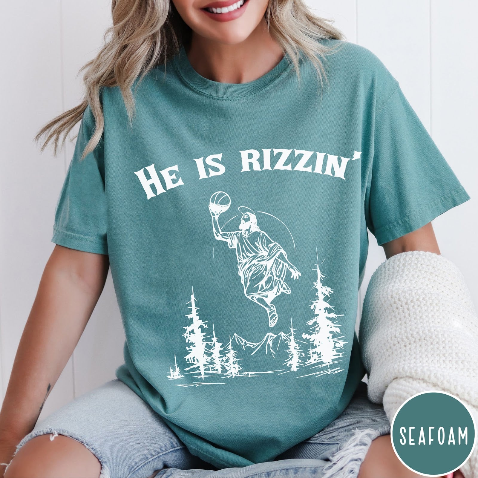 Comfort Colors tee in Seafoam featuring graphic style Jesus playing basketball with mountains and pine trees illustration