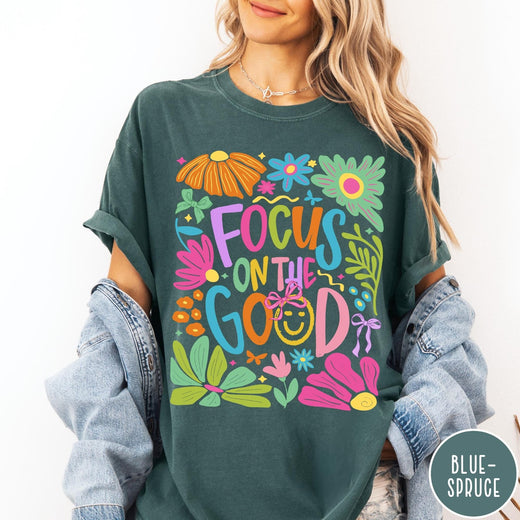Comfort Colors tee in Blue Spruce featuring positivity typography and floral collage graphic with a smiley face.