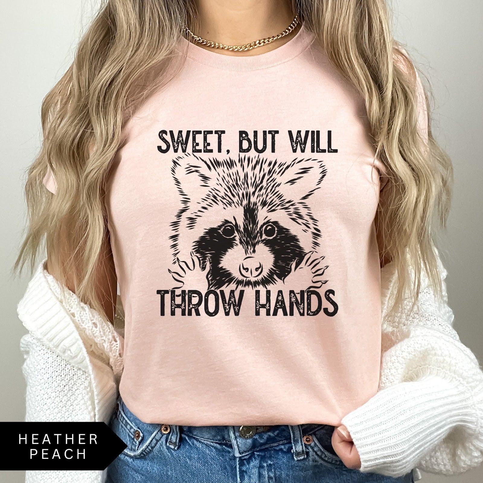 Comfort Colors tee in Heather Peach featuring graphic style raccoon illustration with text Sweet, but will throw hands