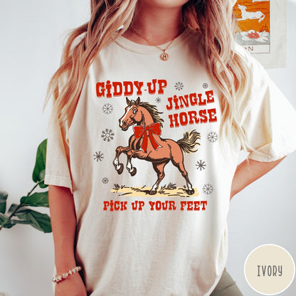 Comfort Colors tee in Ivory featuring festive holiday graphic with a prancing horse wearing a red bow