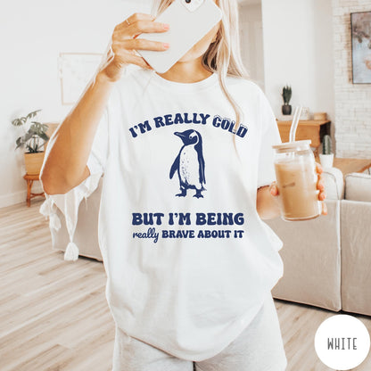 Comfort Colors tee in White featuring penguin graphic with text I am really cold but I am brave