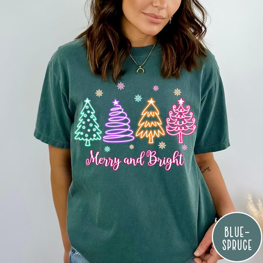 Comfort Colors tee in Blue Spruce featuring neon Christmas tree graphic with Merry and Bright text and snowflakes