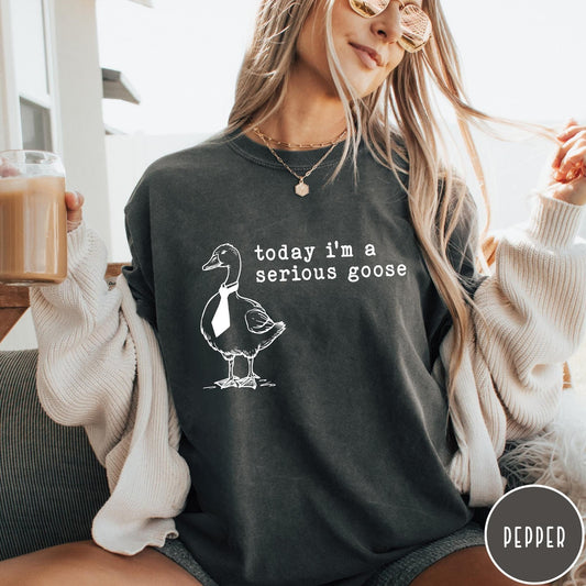 Comfort Colors tee in Pepper featuring minimalist graphic design of a goose wearing a necktie and text