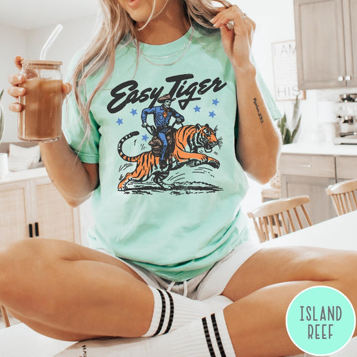 Comfort Colors tee in Island Reef featuring western graphic style cowboy riding a tiger with blue stars