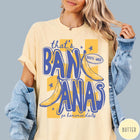 Comfort Colors tee in Butter featuring retro style banana graphic with text that is bananas go bananas daily