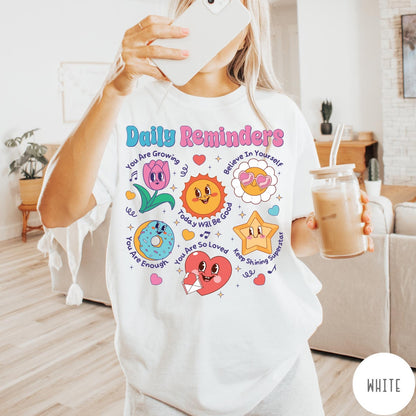 Comfort Colors tee in White featuring retro mascot graphic with daily affirmations and cute cartoon characters