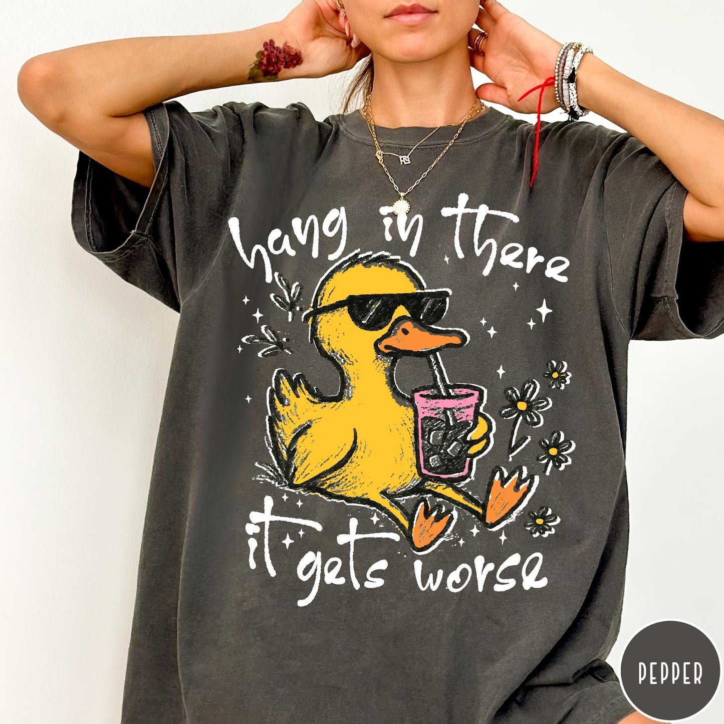 Comfort Colors tee in Pepper featuring illustrated duck graphic wearing sunglasses and drinking a pink iced beverage
