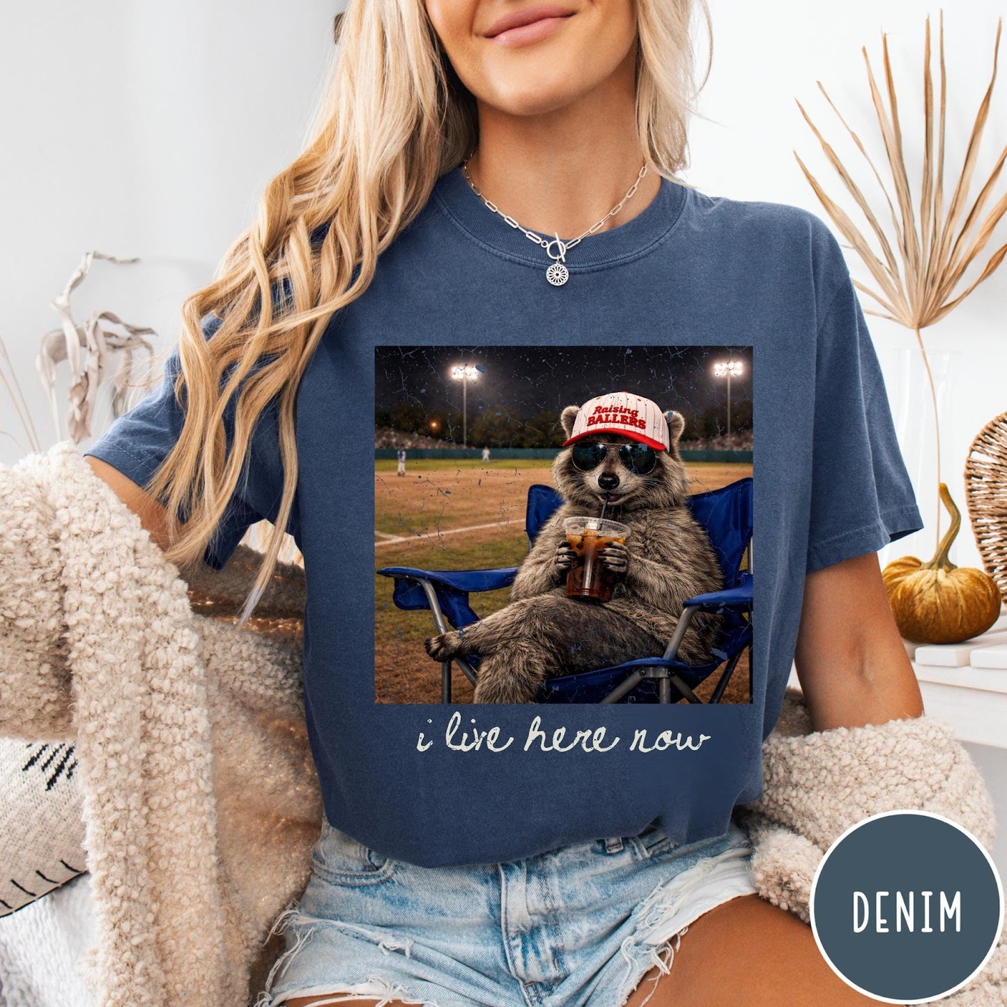 Comfort Colors tee in Denim featuring graphic style raccoon wearing sunglasses and baseball cap at a stadium